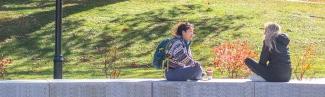 students sit outside during fall on the biddeford campus